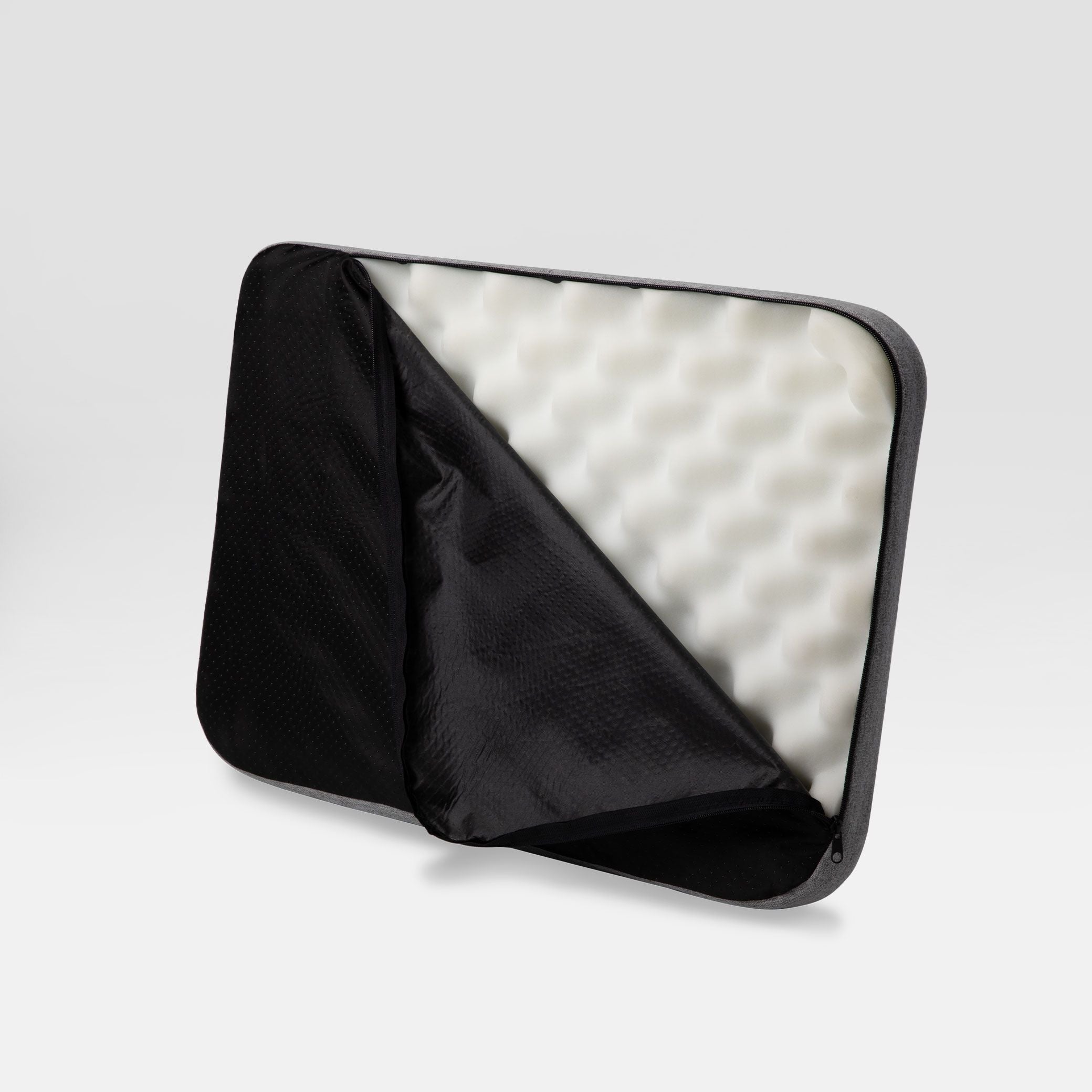 Bottom view of Bolstr dog bed, with cover partially unzipped to show memory foam inside.